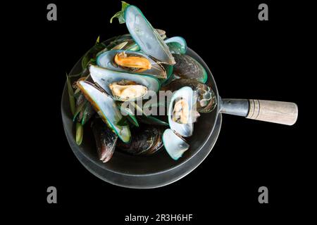 Tagliare le cozze a vapore in una pentola su nero isolato. Foto Stock