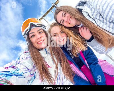 Gruppo di amici felici sciatore prendere selfie trekking montagne. Le ragazze sorridenti rendono Selfie in abbigliamento da sci su Snow Mountain. Restin Foto Stock