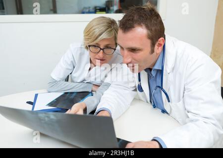 due medici che esaminano il rapporto radiologico in ufficio medico Foto Stock