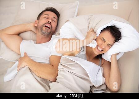 l'uomo russava mentre sua moglie copre le orecchie Foto Stock