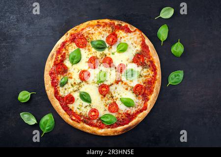 Tradizionale pizza italiana napoletana margherita con pomodori e mozzarella servita come vista dall'alto su una vecchia tavola rustica con testo Foto Stock