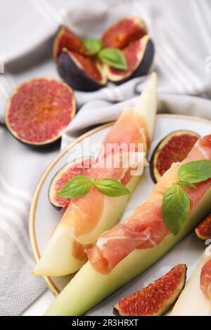 Gustosi meloni, jamon e fichi serviti sul tavolo, primo piano Foto Stock