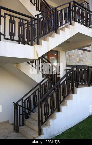 Vista di belle scale con corrimano in metallo vicino casa all'aperto Foto Stock