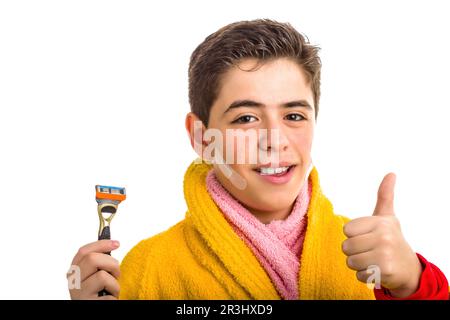 Ragazzo in accappatoio giallo e asciugamano rosa che tiene un rasoio fa segno di successo Foto Stock