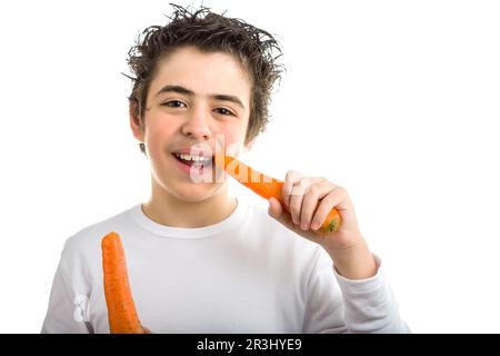 Ragazzo caucasico dalla pelle liscia che mangia carota biologica Foto Stock