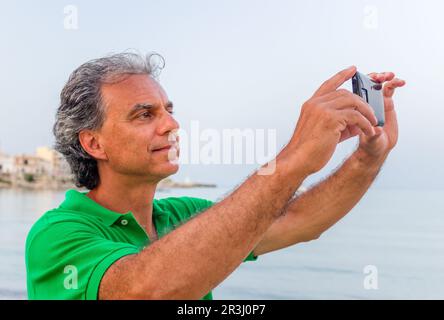 Bell'uomo prende un selfie in città di mare Foto Stock