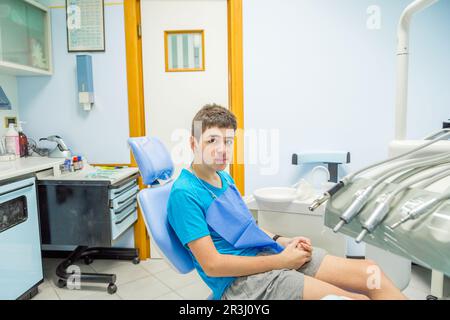 Ragazzo seduto sulla sedia del dentista Foto Stock