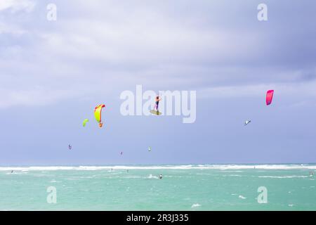 Kiteboarding. Divertimento nell'oceano. Sport estremo Kitesurf. Kitesurfer che salta in alto nell'aria che esegue le trick durante la sessione di kitesurf Foto Stock