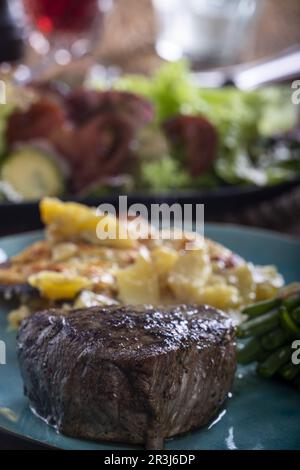 Bistecca con fagioli e patate gratinate Foto Stock