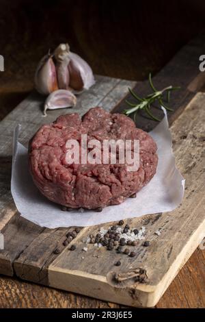 Carne macinata cruda su legno scuro Foto Stock