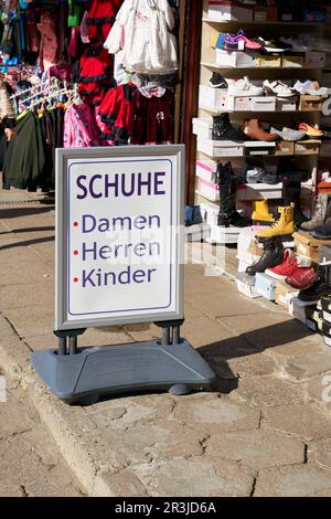 Firma con testo tedesco in un mercato a Swinoujscie, Polonia. Scarpe per Signore, uomini, bambini Foto Stock