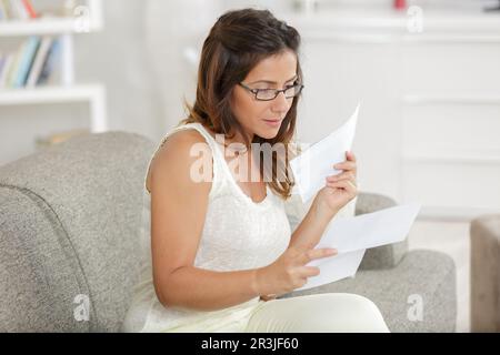 donna soddisfatta che legge una lettera nel paese Foto Stock