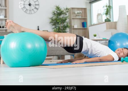 la donna atletica fa gli esercizi su una sfera di idoneità Foto Stock