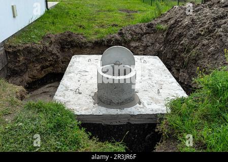 Serbatoio settico in cemento con una capacità di 10 metri cubi posto nel giardino dalla casa, acqua visibile sotto. Foto Stock