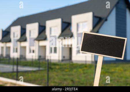 Blank cartellone nero contro casa di famiglia appartamento modello mockup vuoto etichetta Blackboard a Townhome. Copia banner spazio per y Foto Stock