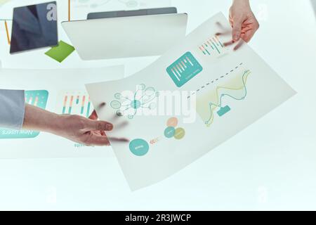 Incontro degli ingegneri nel laboratorio di ricerca tecnologica: Ingegneri, scienziati e sviluppatori si sono riuniti intorno al tavolo della conferenza illuminata. Ispezione Foto Stock