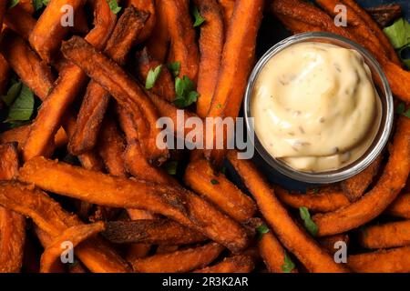 Deliziose patatine dolci servite con salsa, primo piano Foto Stock