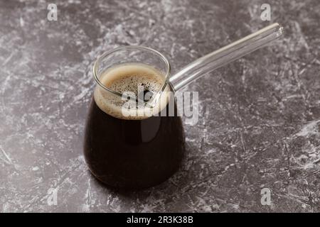 Caffè turco in vetro cezve su tavolo in marmo grigio Foto Stock