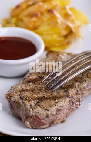 Bistecca su un piatto con patate gratinate Foto Stock