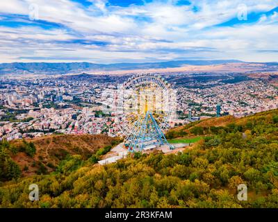 Vista panoramica aerea di Ferris o ruota gigante nel Parco Mtatsminda di Tbilisi. Tbilisi è la capitale e la più grande città della Georgia sul fiume Kura. Foto Stock