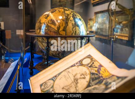 Un globo storico e un atlante che raffigurano le mappe del mondo esposte al museo Queen's House di Greenwich, Londra, Regno Unito. La casa è stata progettata da Foto Stock