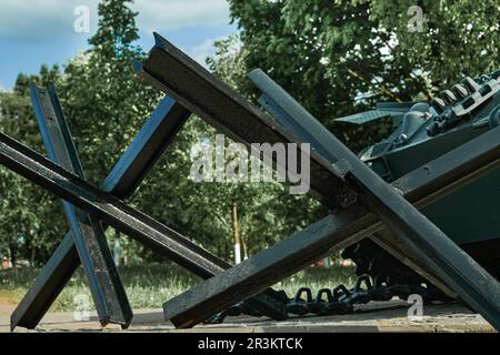 Ricci anticarro e closeup serbatoio e sfondo tranquillo. Monumento alle vecchie armi primo piano. Simbolo della fine della guerra. Vecchie armi militari. AG Foto Stock