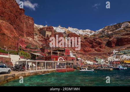 Amoudy Bay Red Volcanic Cliffs - pesca barche e ristoranti nel Mar Egeo - Santorini Island, Grecia Foto Stock