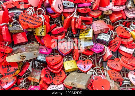 Verona, Italia - Giugno 2022: Sfondo di chiuse a forma di cuore su una parete, simbolo dell'amore per sempre. Foto Stock