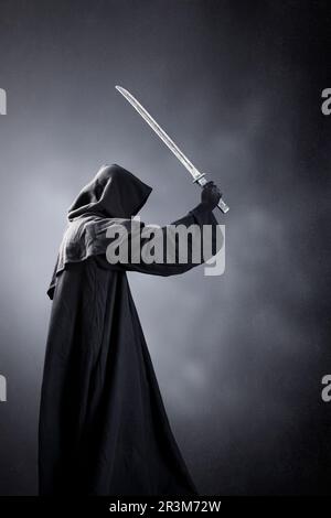 Guerriero Samurai con spada katana su sfondo oscuro e misterico Foto Stock