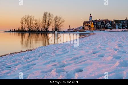 Faro di Urk durante l'inverno con la neve nei Paesi Bassi. Villaggio olandese in inverno con la neve Foto Stock