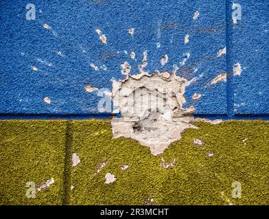 Esplosione danneggiato blu giallo casa muro guerra in Ucraina Foto Stock