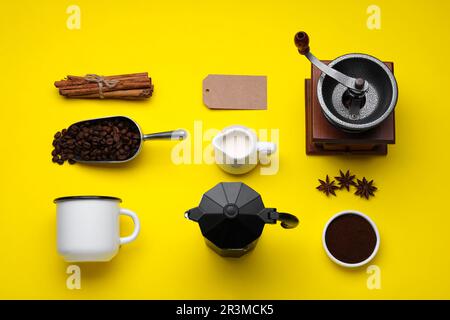 Composizione a posa piatta con macinacaffè manuale vintage e macchina per caffè geyser su sfondo giallo Foto Stock