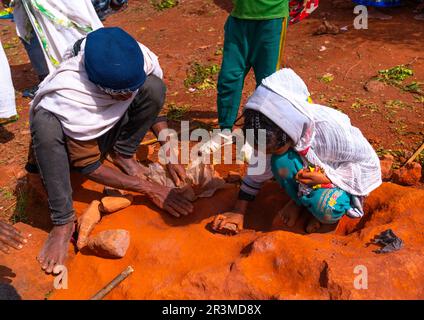 Etiopici che raccolgono sassi nella chiesa scavata nella roccia di Bilbaia Giorgis, regione di Amhara, Lalibela, Etiopia Foto Stock
