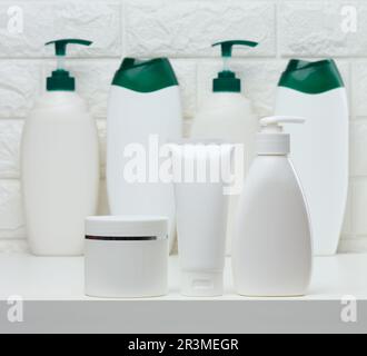 Vasetti e tubi in plastica bianca per cosmetici liquidi su fondo bianco. Branding, pubblicità Foto Stock