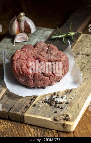 Carne macinata cruda su legno scuro Foto Stock