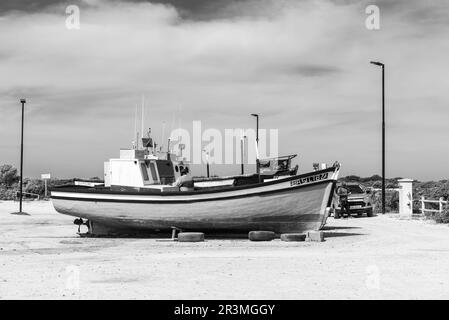 Struisbaai, Sudafrica - 21 settembre 2022: Barche da pesca al porto di Struisbaai, nella provincia del Capo Occidentale. Le persone sono visibili. Monocromatico Foto Stock