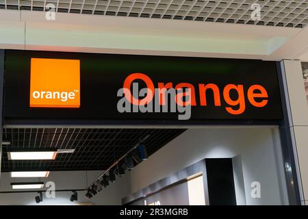 Insegna illuminata della società di telecomunicazioni francese Orange in un negozio in Polonia Foto Stock