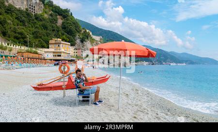 Spiaggia di ciottoli Monterosso vacanze Sedie e ombrelloni sulla spiaggia delle cinque Terre. Foto Stock