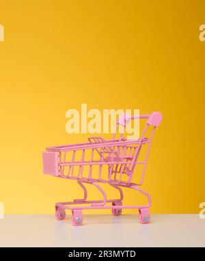 Carrello vuoto in miniatura su sfondo blu. Vendita stagionale Foto Stock