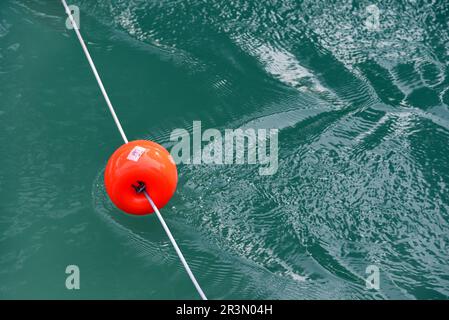 Galleggianti di plastica Red boe che creano ripple in acqua corrente Foto Stock