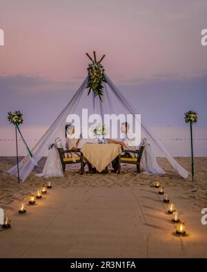 Cena romantica in spiaggia, cena in luna di miele in spiaggia al tramonto in Thailandia, ambiente di San Valentino Foto Stock