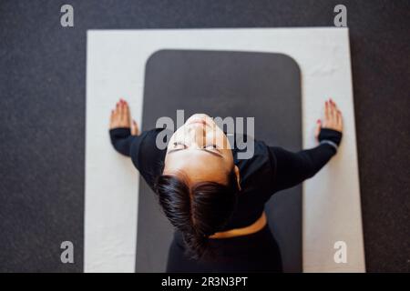 Giovane donna bella stretching e riscaldamento prima di allenarsi in palestra Foto Stock