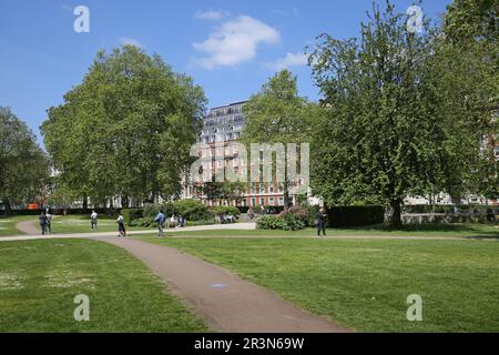 Grosvenor Square, Mayfair, Londra, Regno Unito. Nei giardini centrali si gode il sole e il tempo estivo. Foto Stock
