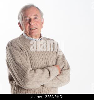 Anziani: Uomo maturo. Ritratto di testa e spalla di un uomo anziano sorridente con braccia piegate. Da una serie di immagini correlate. Foto Stock