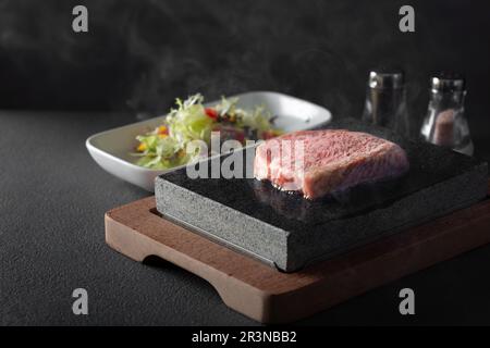 Miyazaki giapponese A5 Wagyu su una bistecca di，sirloin di pietra calda su una pietra molto calda. Foto Stock