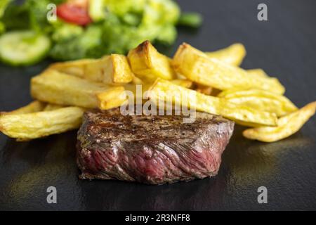 Bistecca con patatine fritte sull'ardesia Foto Stock