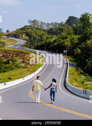 Una coppia camminando su una strada curva nelle montagne di Nan Thailandia, strada nr 3 strada di campagna Foto Stock