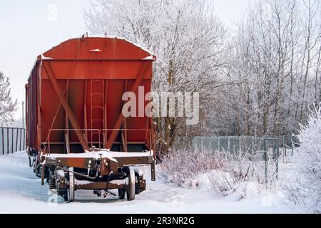 Carrozze di un treno merci in piedi su una linea ferroviaria coperta di neve Foto Stock