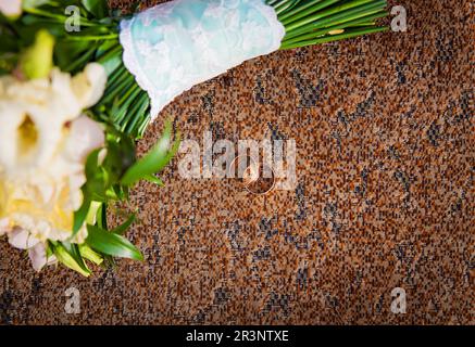Anello e bouquet di fiori diversi su una sedia Foto Stock