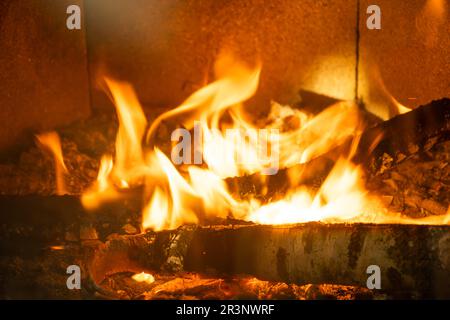 Legna da ardere sta bruciando nel forno del primo piano del focolare. Riscaldamento ecologico alternativo, camera calda e accogliente a casa, woo bruciante Foto Stock